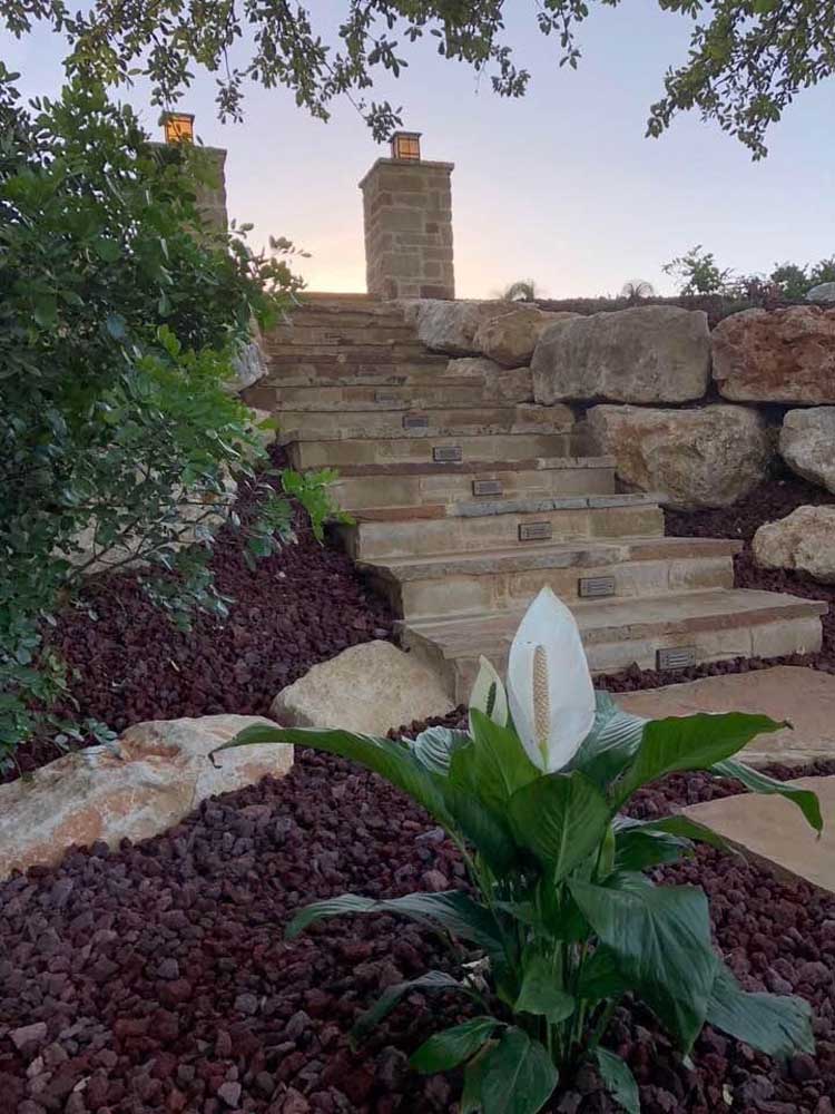 lava rocks in a san antonio flower bed along with freshly planted flowers